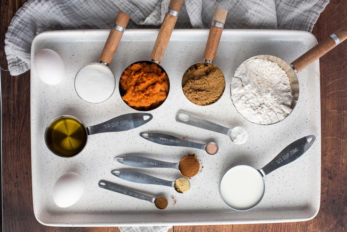 Ingredientes necesarios para panqueques de calabaza, en una bandeja blanca.