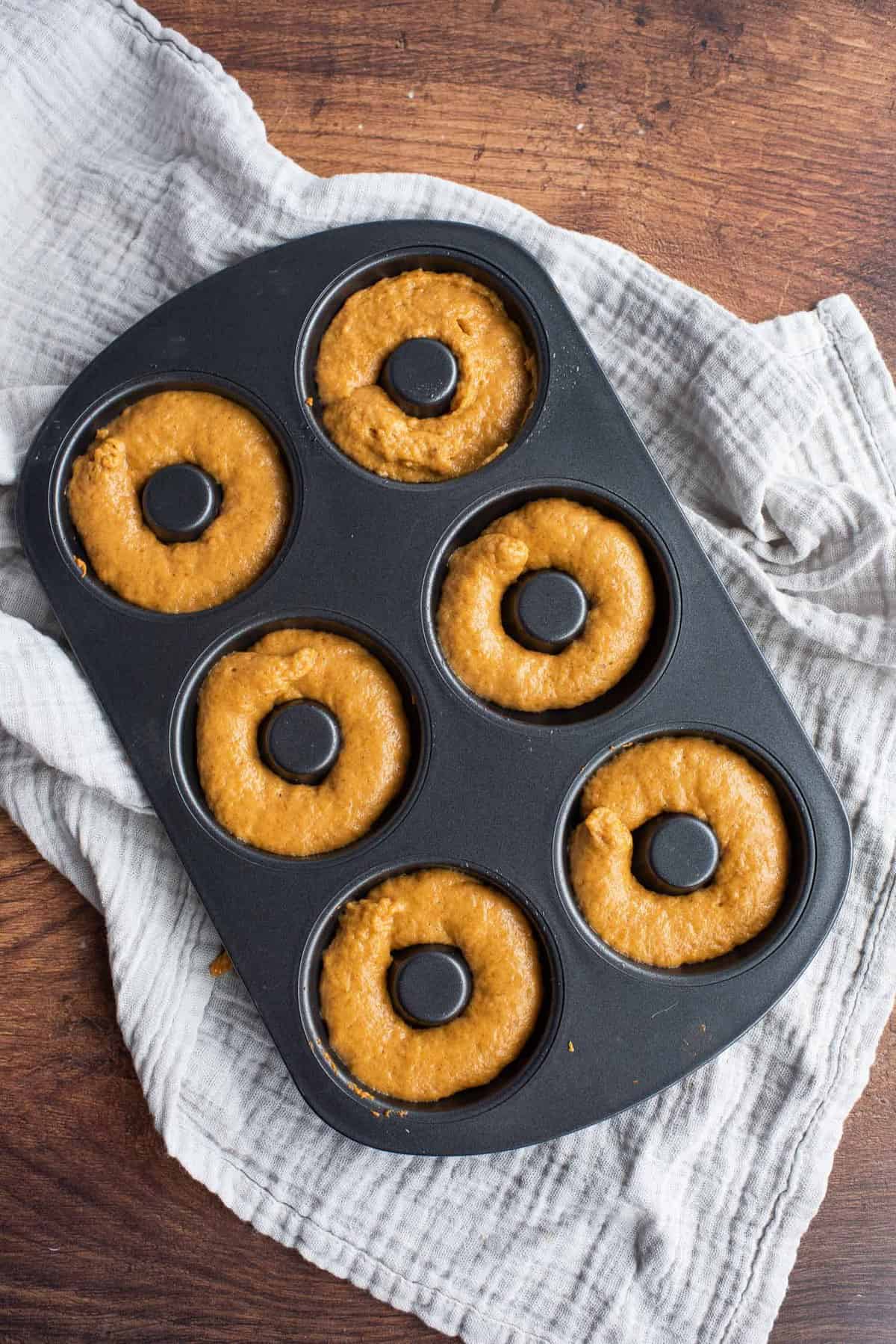 Panqueques de calabaza sin hornear en un molde negro para panqueques.