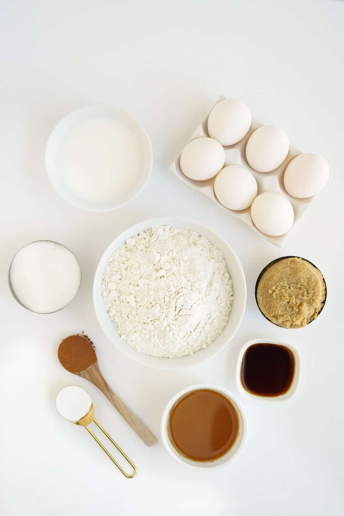 Vista aérea de los ingredientes necesarios para la receta, sobre una superficie blanca.