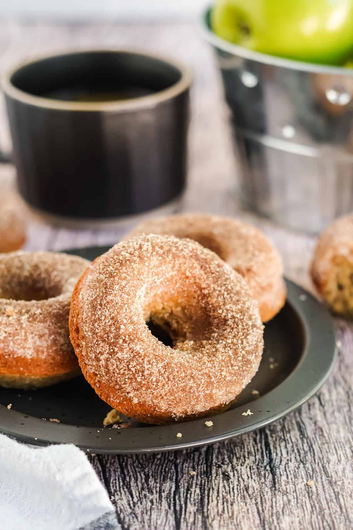 Panqueques en un plato negro con café de fondo.