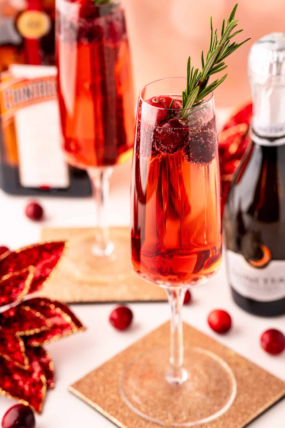 Cóctel de champán rojo con una flor de nochebuena cerca.