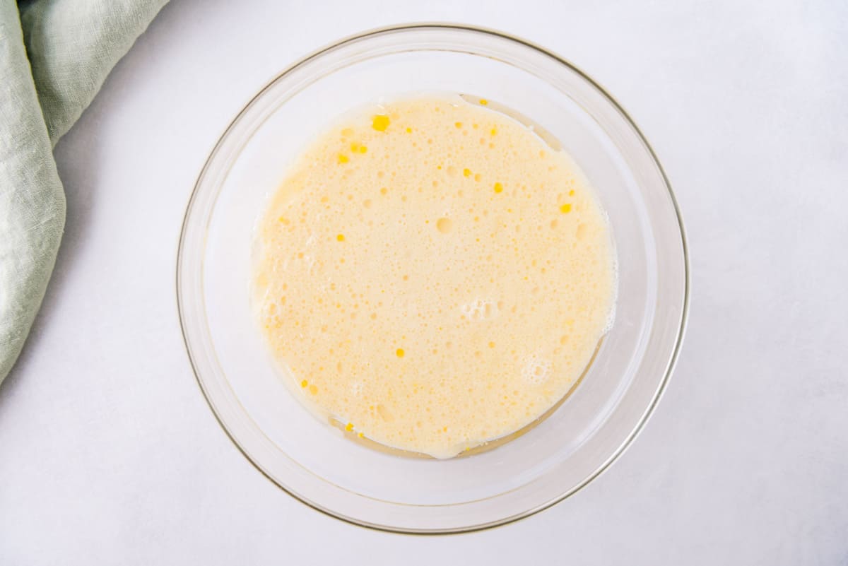 Huevos y leche en un tazón de mezcla de vidrio.