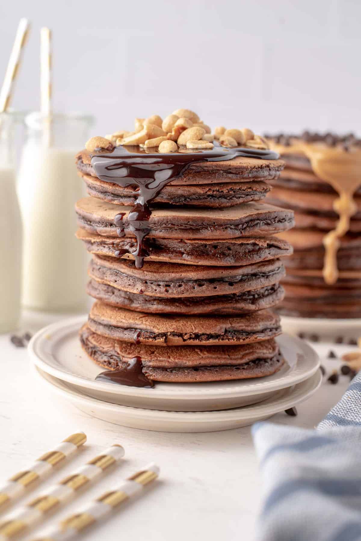 Una pila muy alta de panqueques de chocolate con mantequilla de maní.