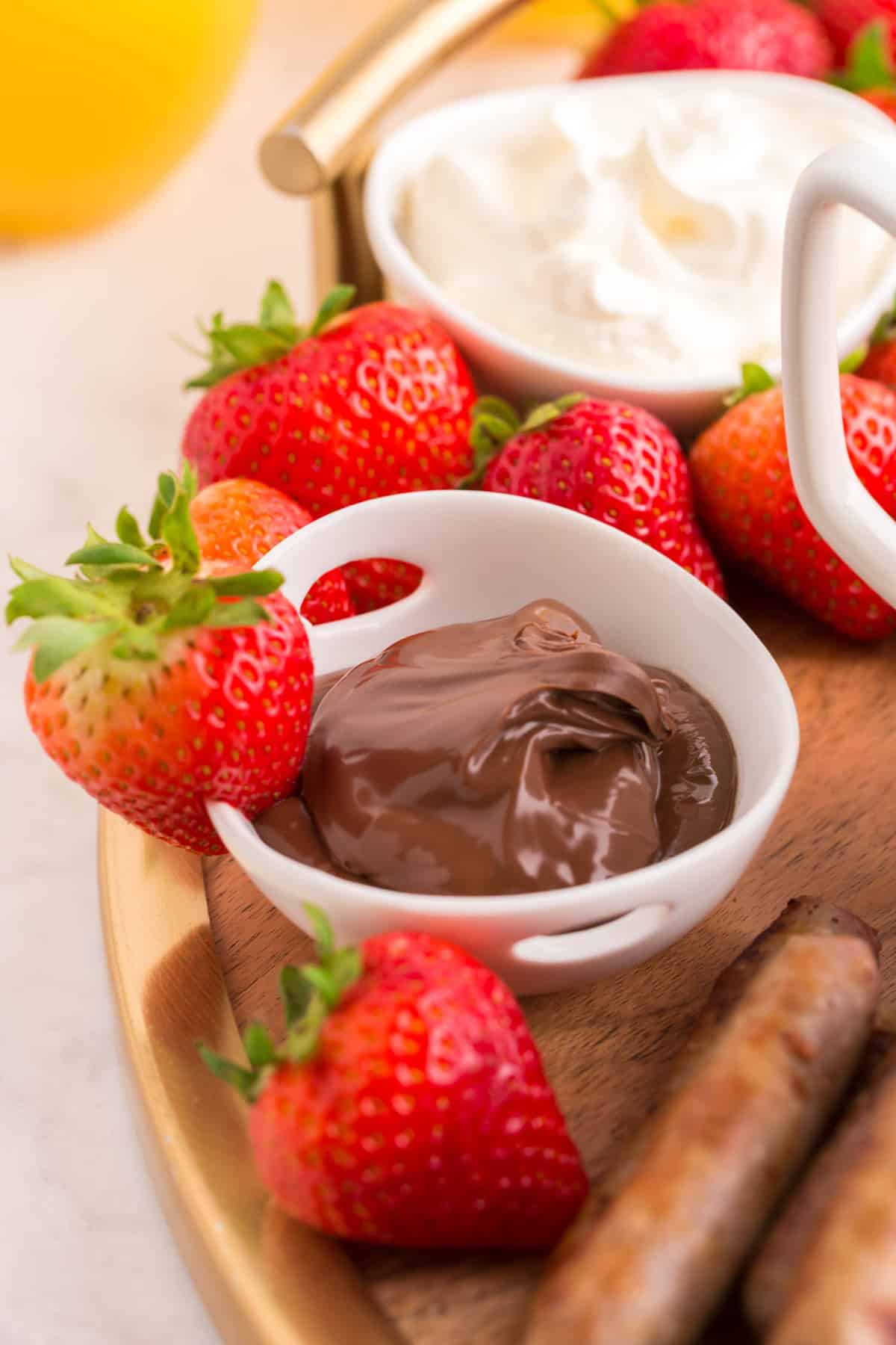 Fresa en el borde de un cuenco de nutella.