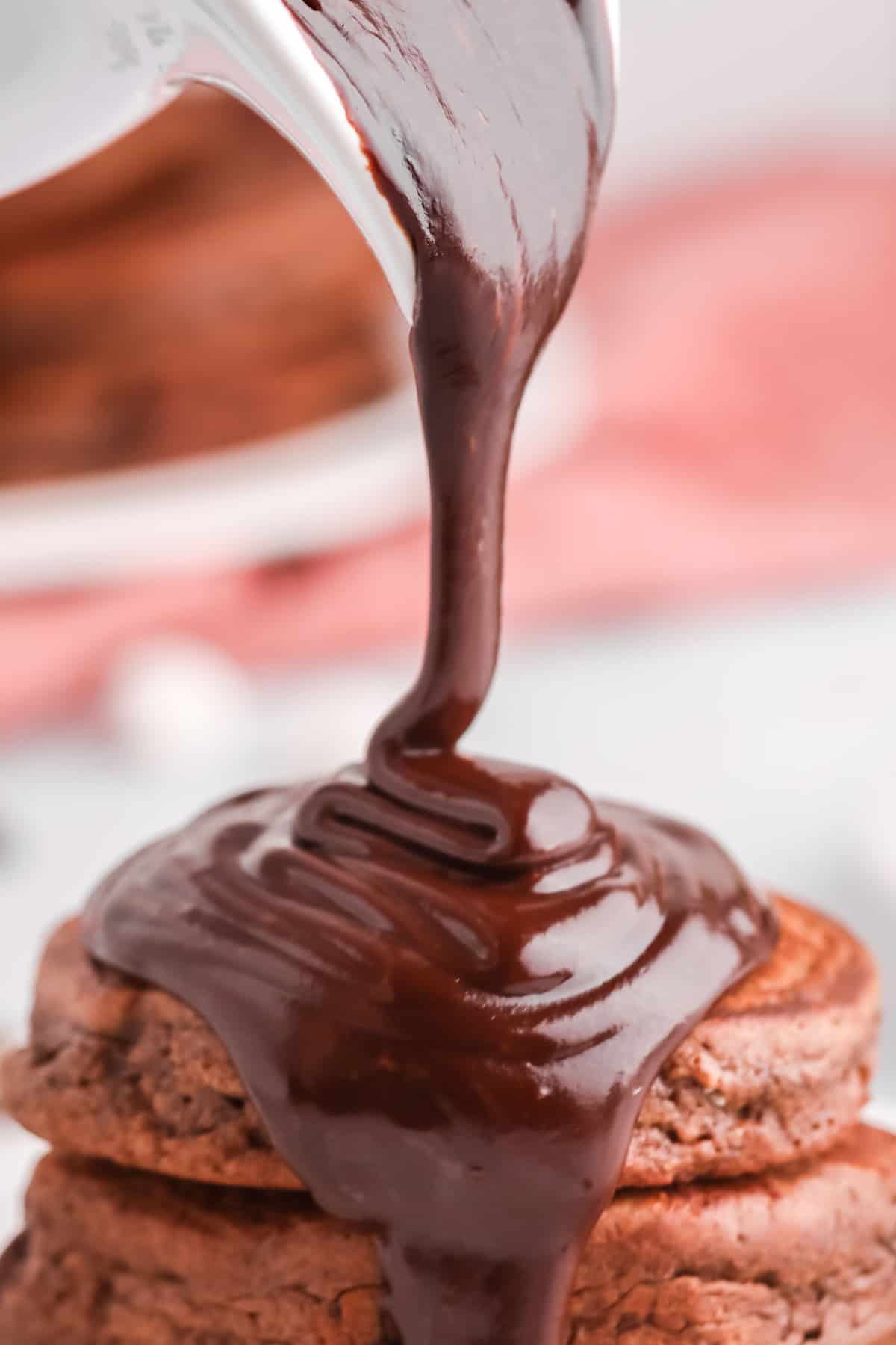 Ganache de chocolate siendo vertida sobre panqueques de chocolate.