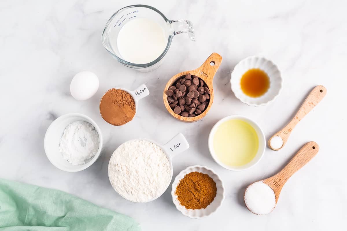Tazones de ingredientes, incluyendo polvo de cacao, chispas de chocolate, harina, polvo de espresso, vainilla y azúcar.