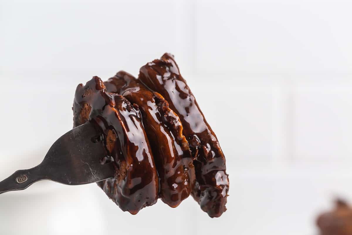 Panqueques de chocolate empapados en chocolate en un tenedor.