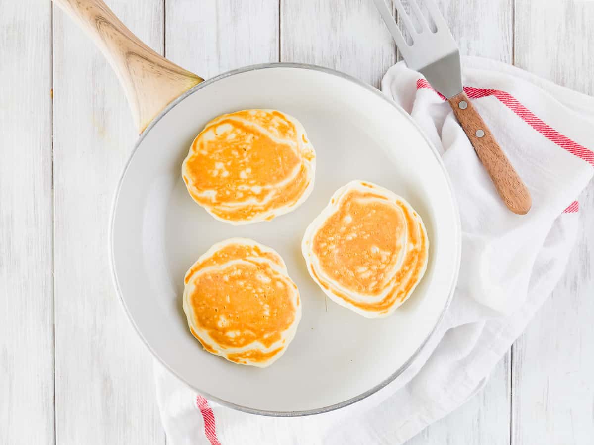 Panqueques cocidos en una sartén blanca.