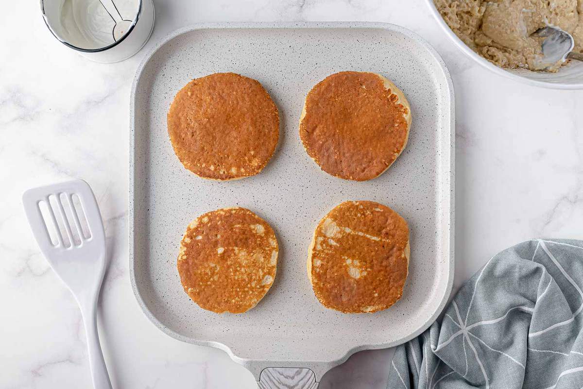 Panqueques cocinados en una plancha blanca.