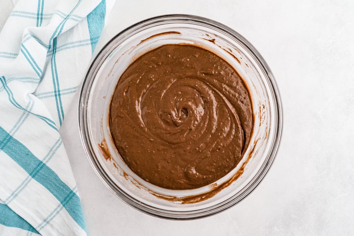 Masa de panqueques de chocolate y mantequilla de maní en un tazón de vidrio claro.