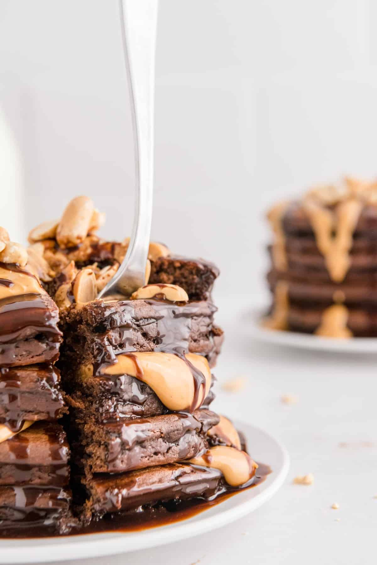 Tenedor saliendo de un montón de panqueques de chocolate con mantequilla de maní.