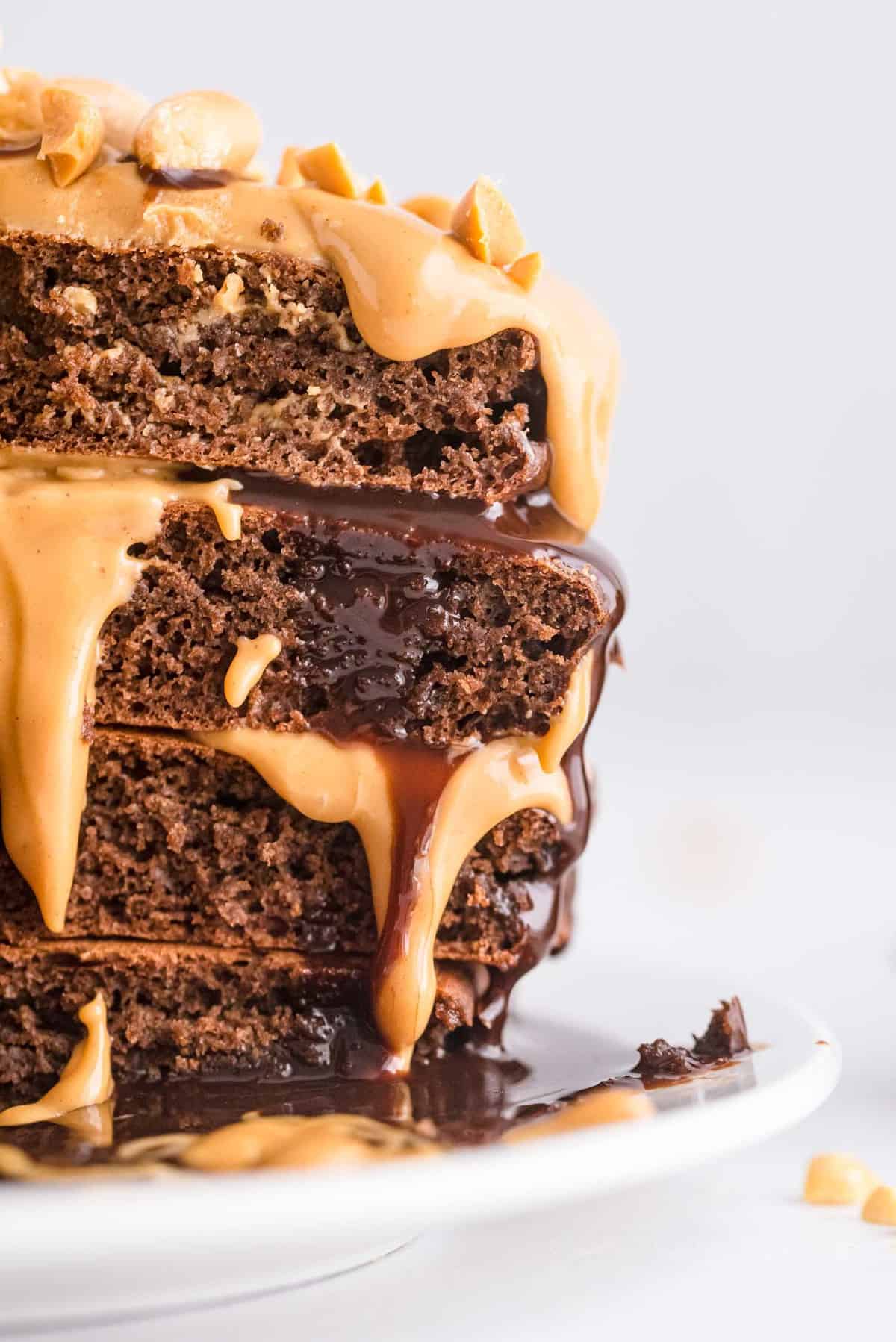 Panqueques cortados para mostrar textura y mantequilla de maní y chocolate rociados encima.