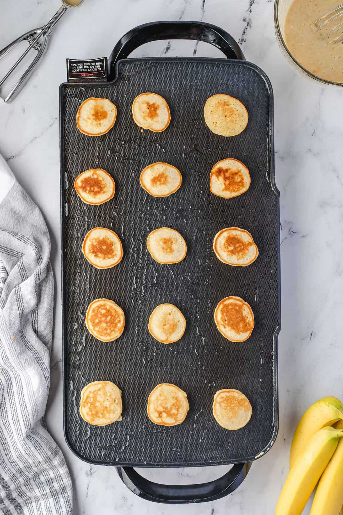 Panqueques cocidos en una plancha grande.