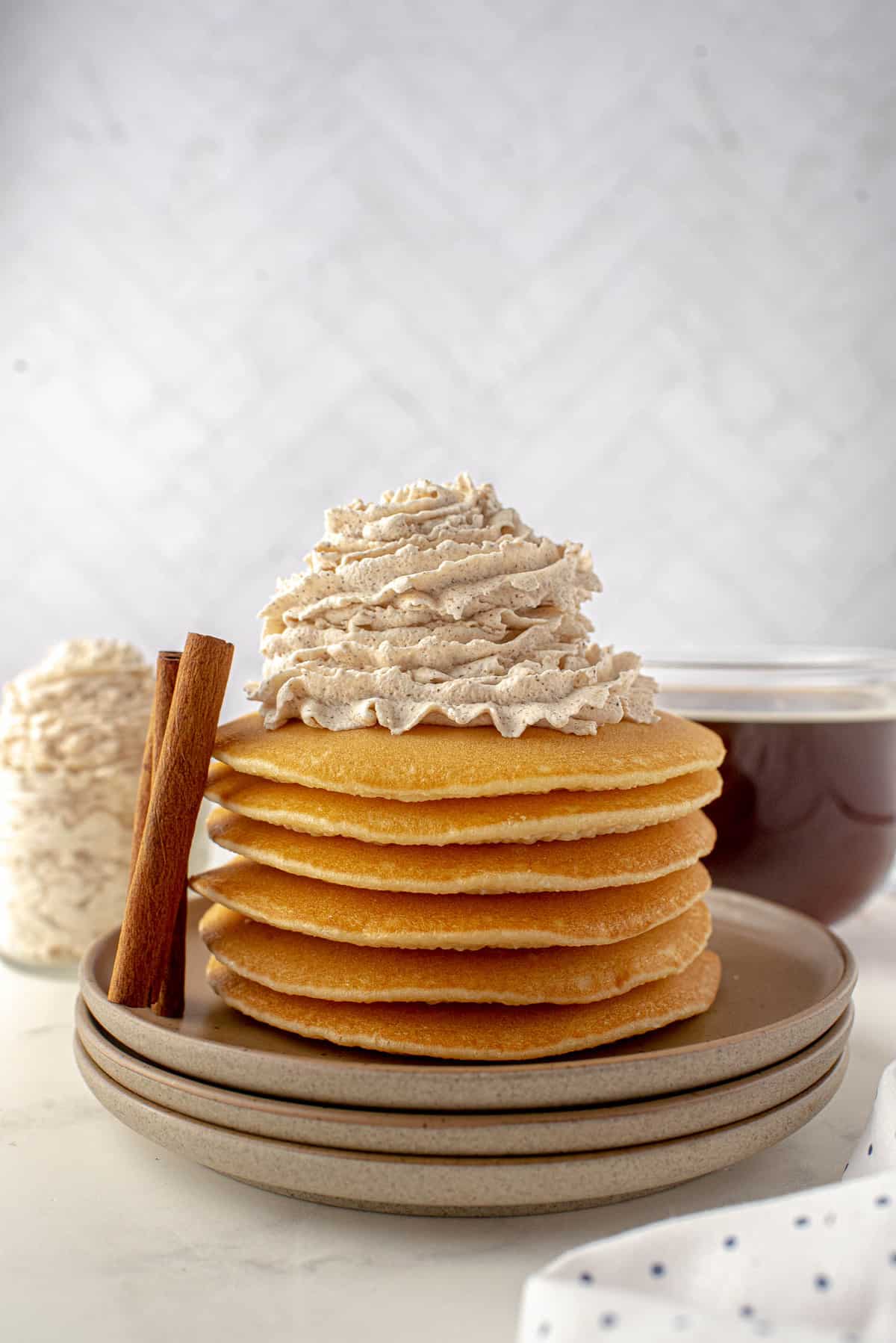 Una pila de panqueques cubiertos con crema batida.