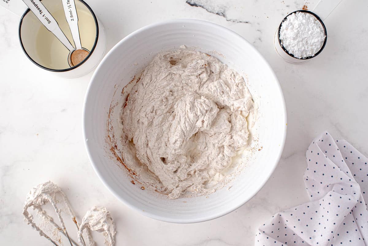 Crema batida de canela en un bol blanco para mezclar.