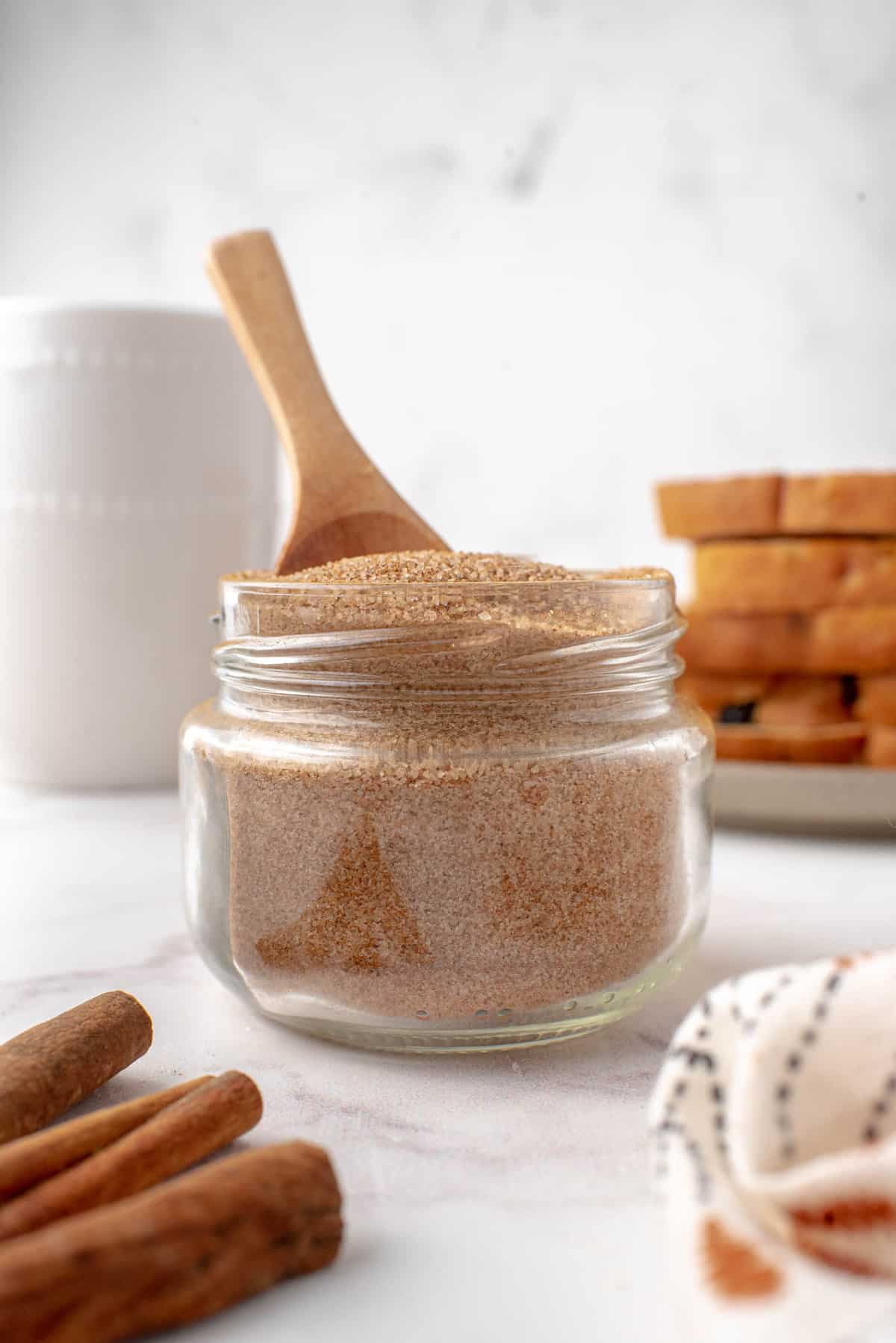 Tarro de mezcla de azúcar de canela con una cuchara de madera.