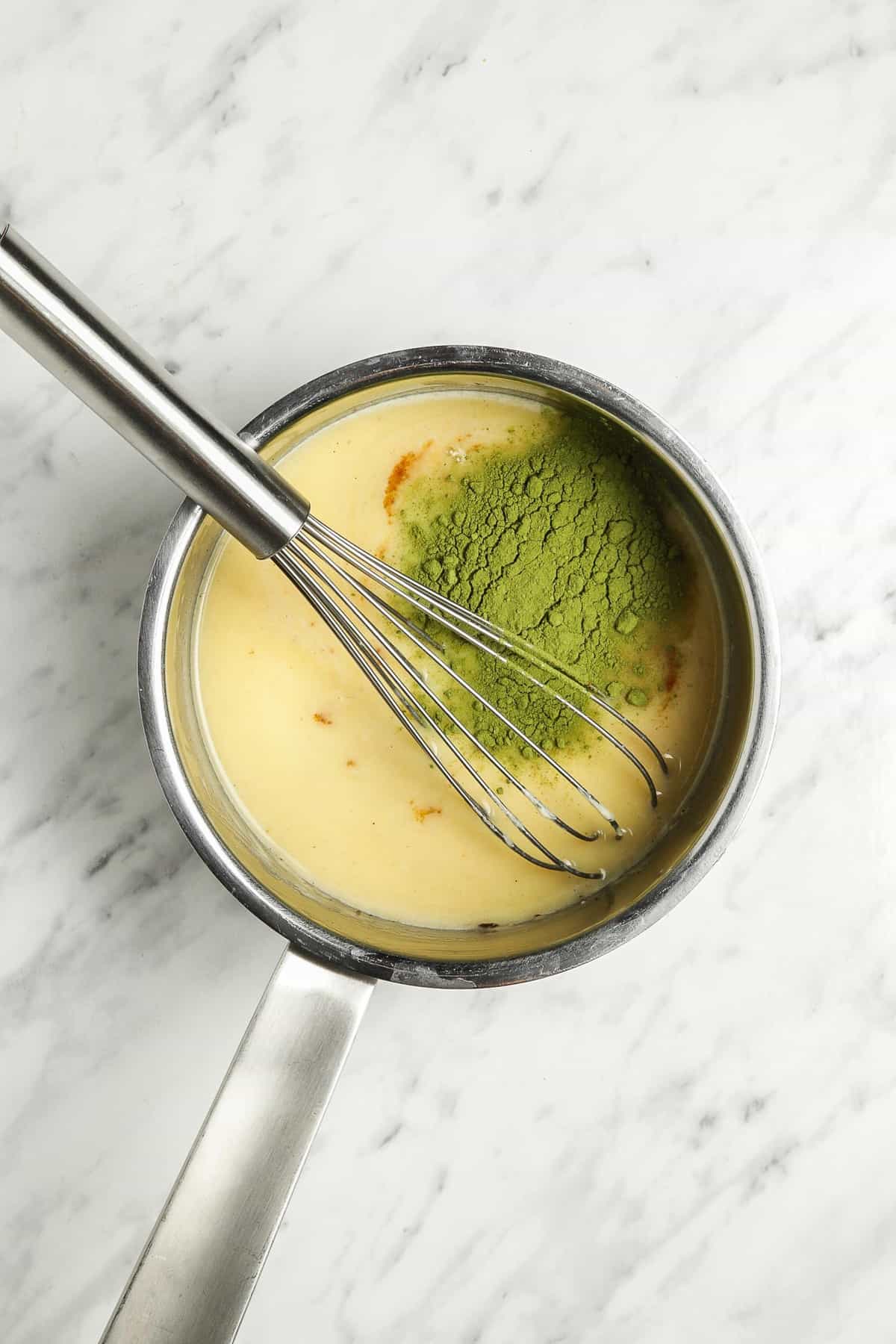 Leche caliente y chocolate blanco con el polvo de matcha añadido.