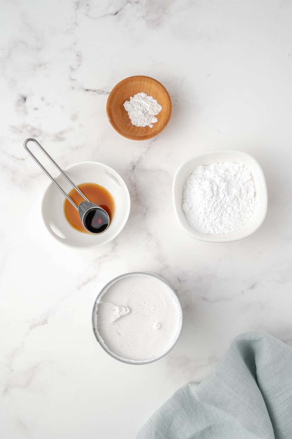 Vista aérea de ingredientes que incluyen crema de coco y extracto de vainilla.