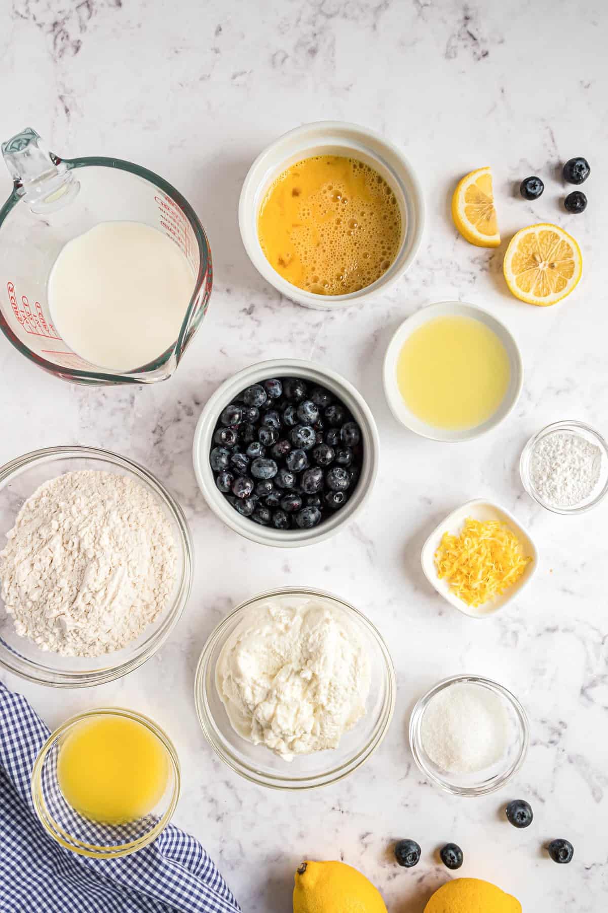 Vista aérea de los ingredientes para hacer panqueques de limón y arándano con ricotta.