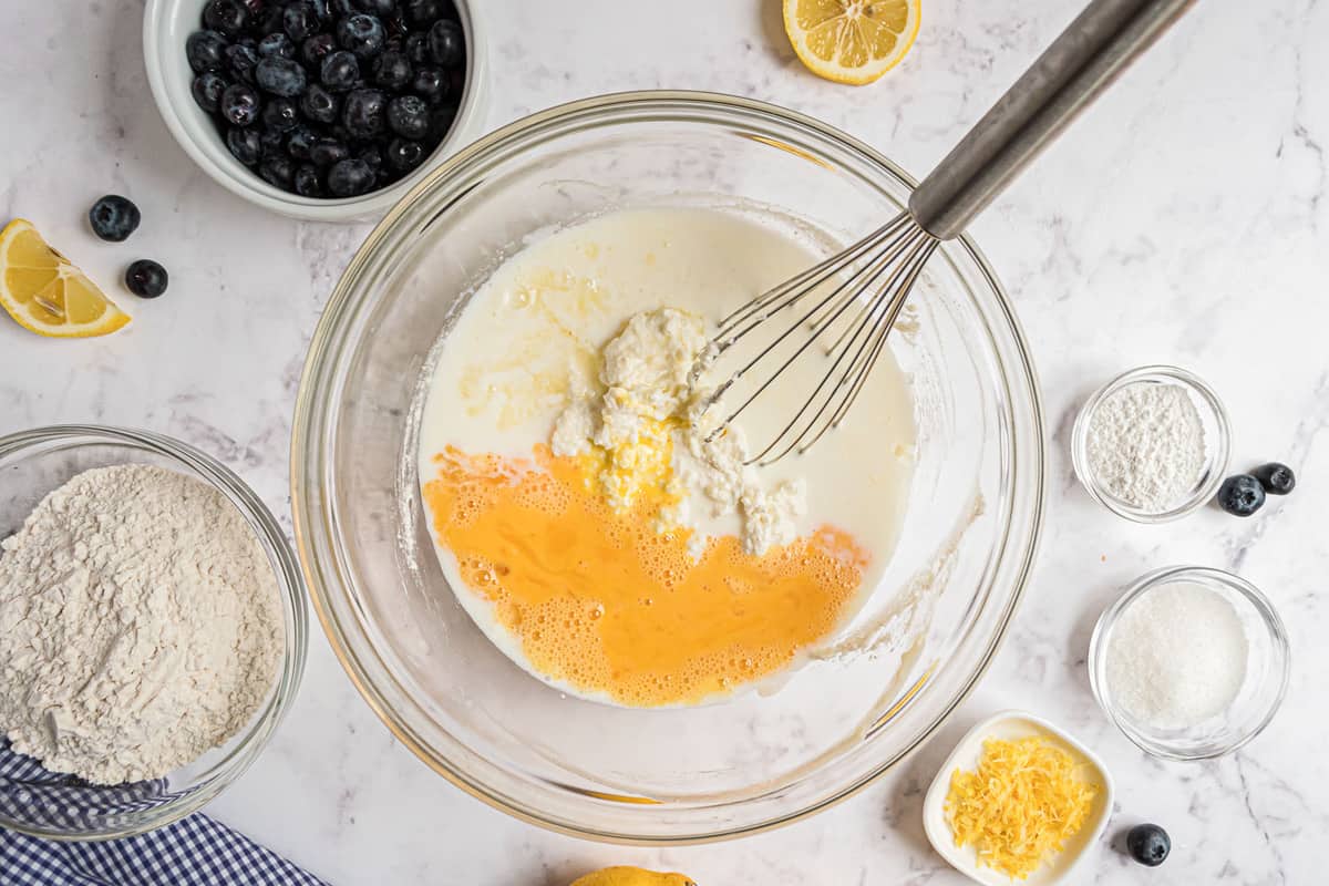 Huevos y leche siendo mezclados en la mezcla de ricotta.