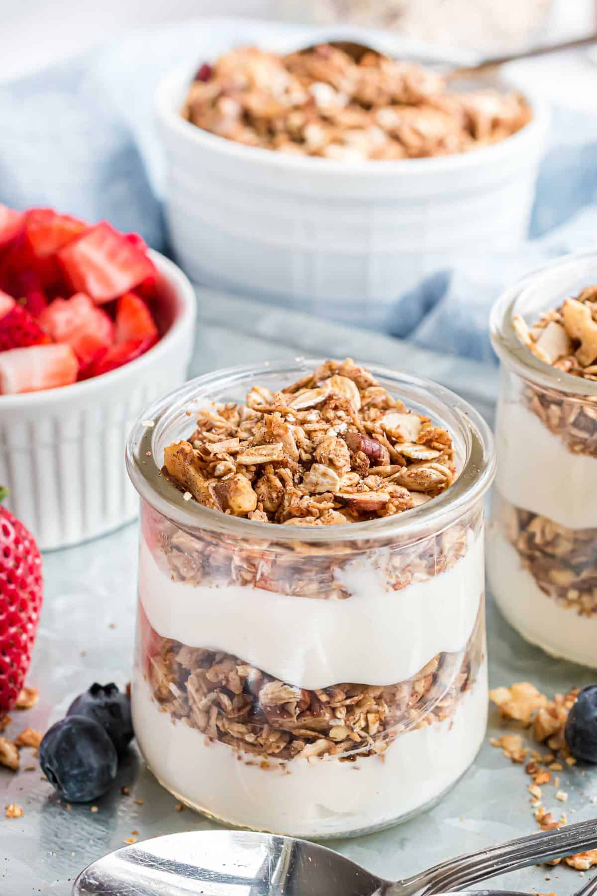 Parfait de granola en pequeño tarro de vidrio, capa de yogur.