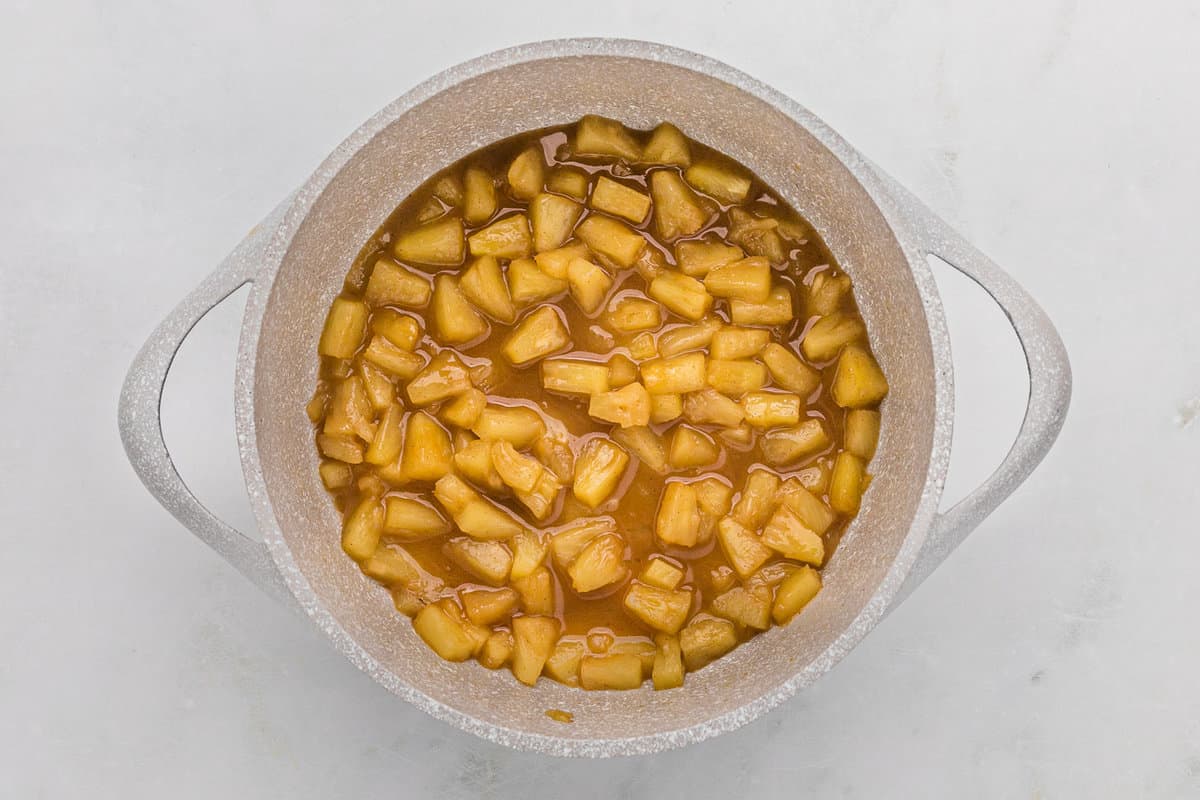 Piña caramelizada en una sartén.