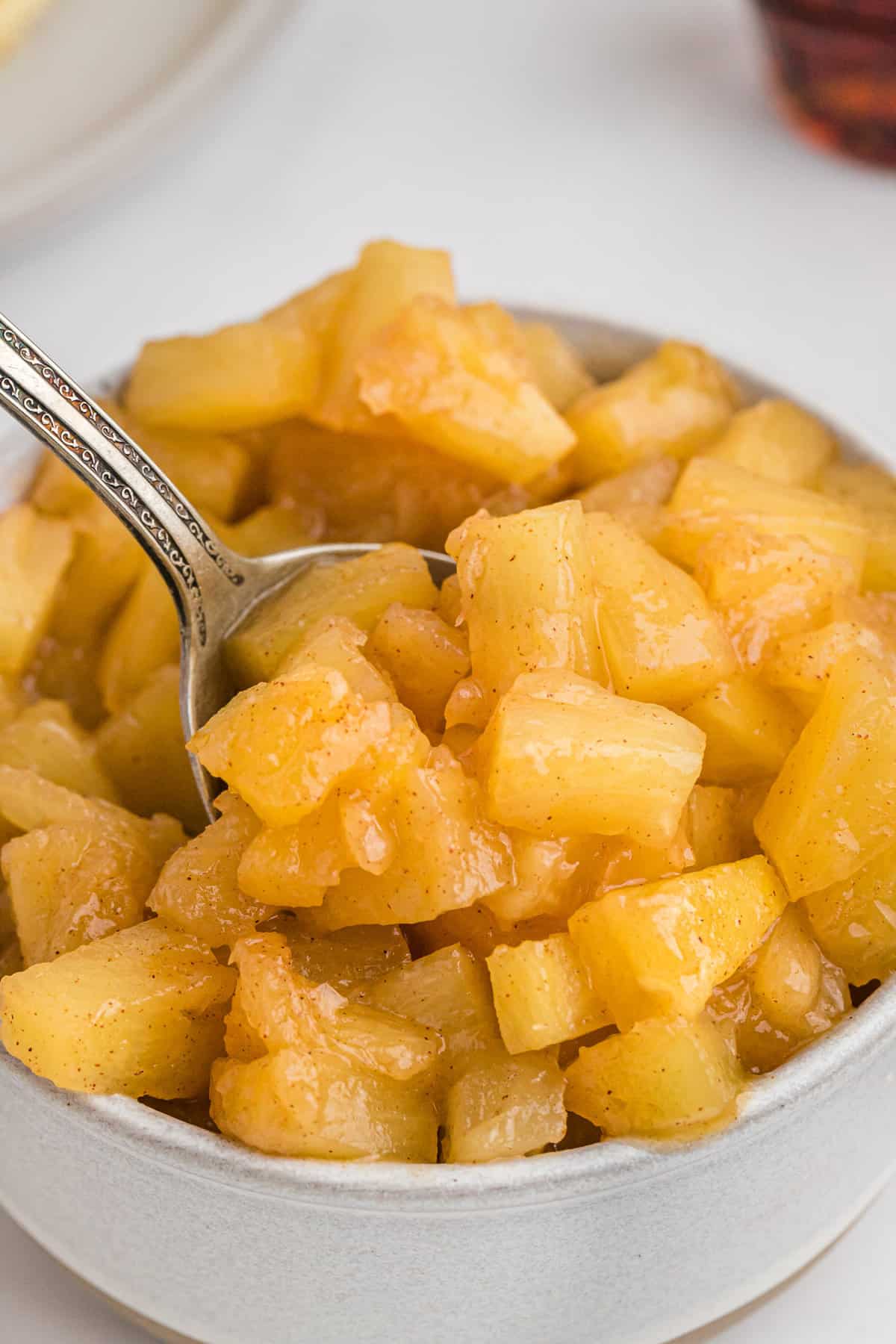Piña en un tazón con una cuchara.