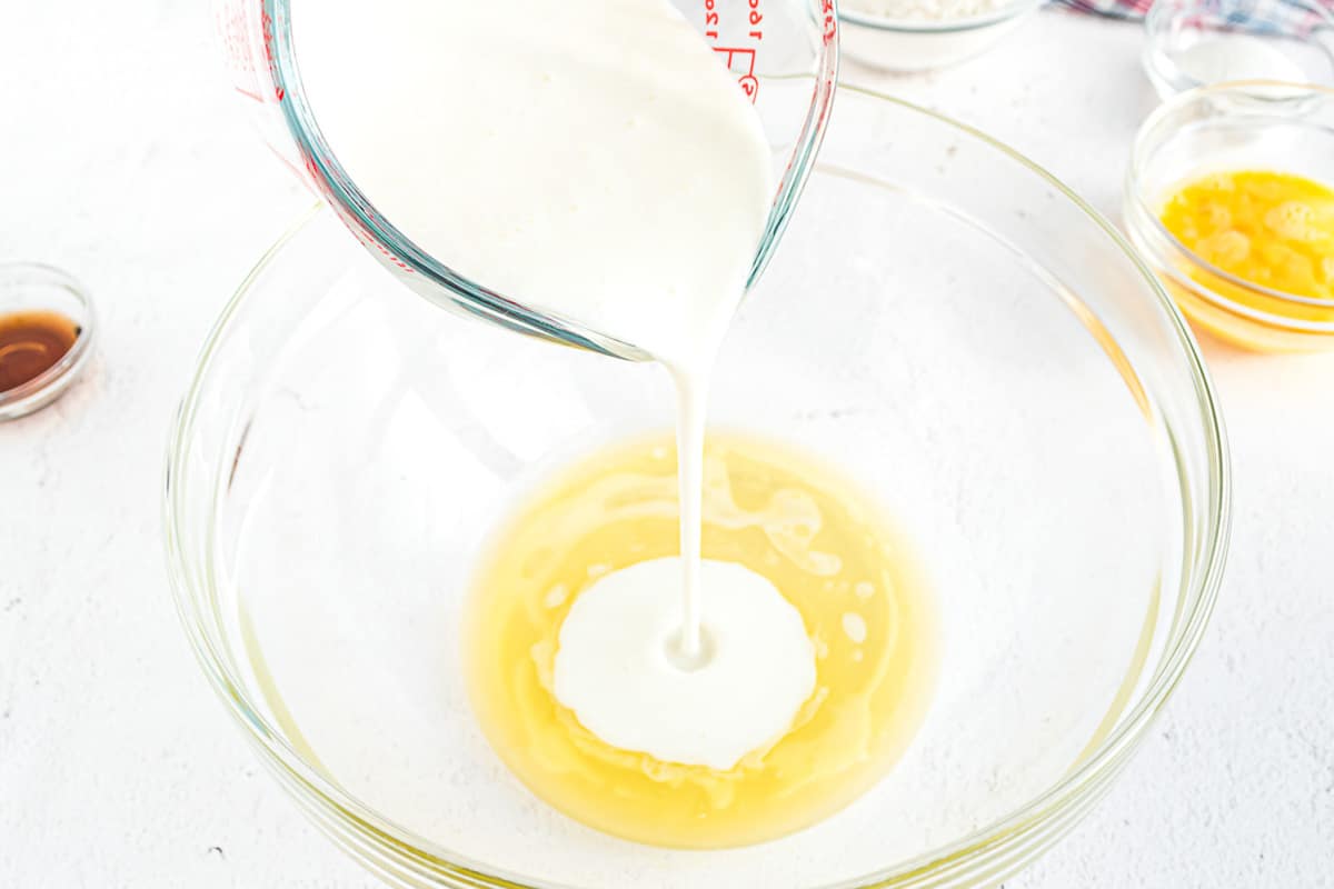 Suero de leche siendo vertido en mantequilla en un tazón claro.