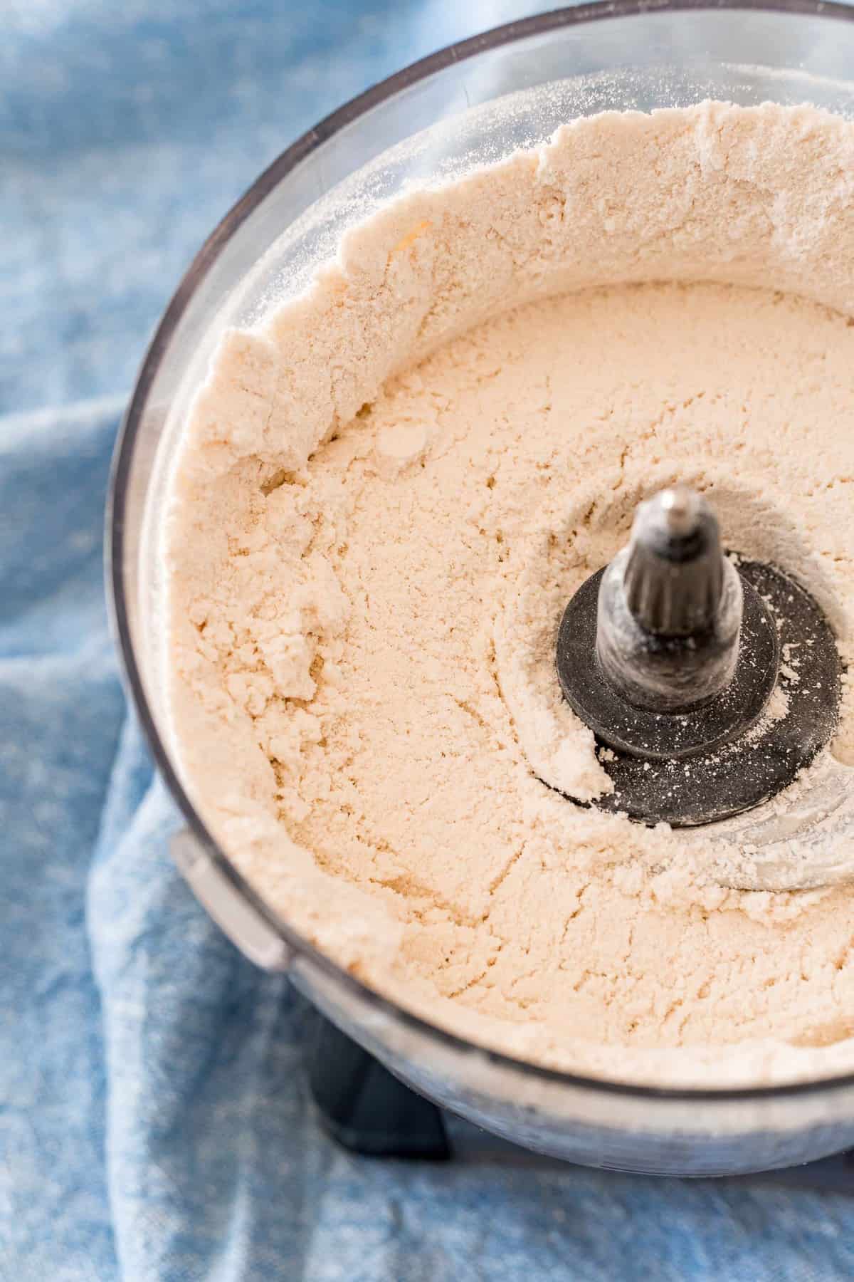Harina y otros ingredientes en un procesador de alimentos.