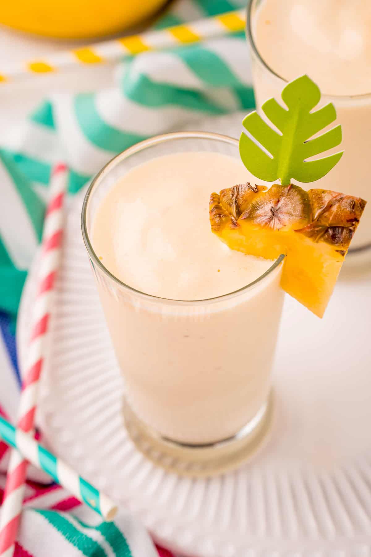 Vista superior del batido de piña decorado con una rodaja de piña fresca.