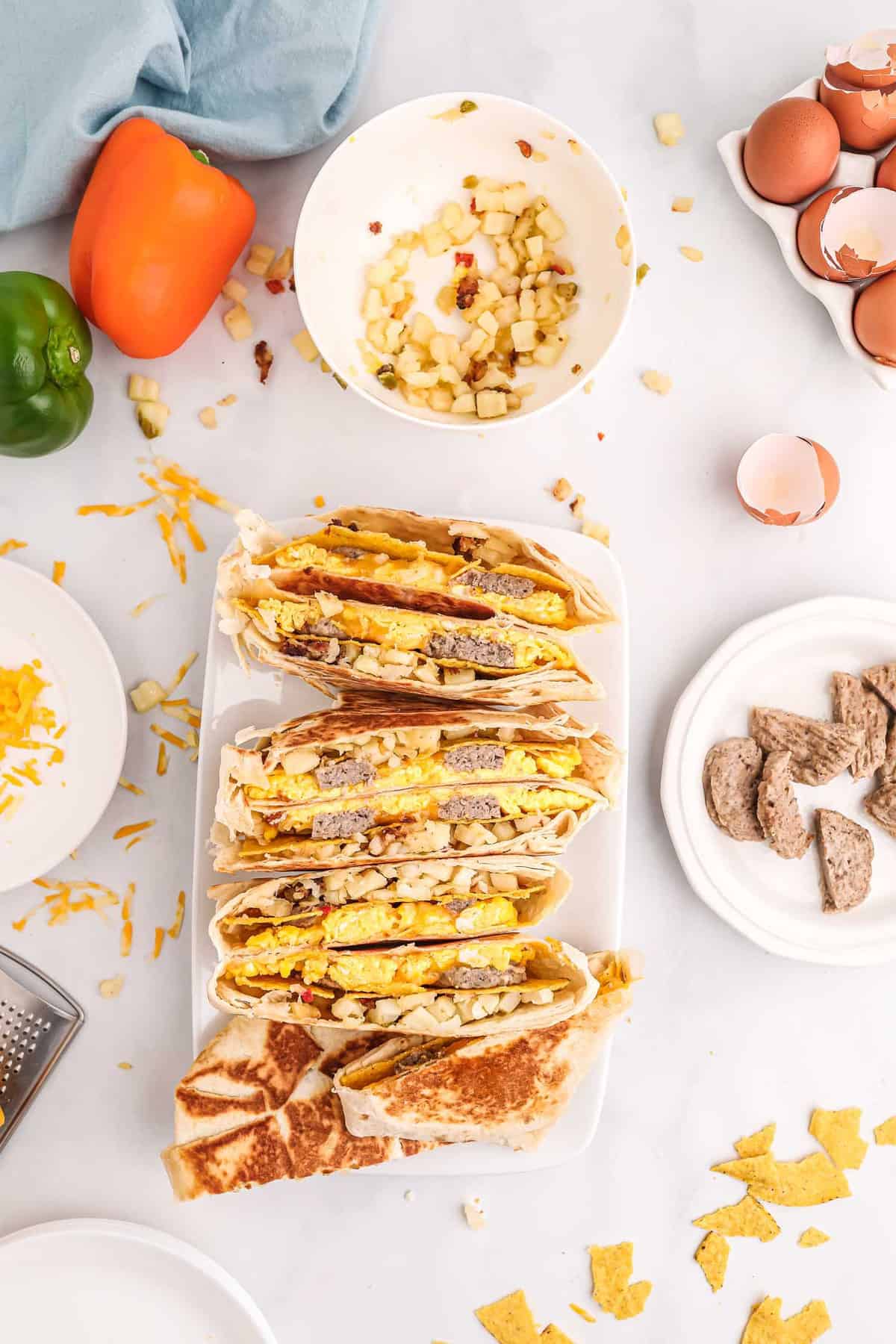 Vista aérea de las mitades de un crunchwrap alineadas en un plato rectangular blanco.