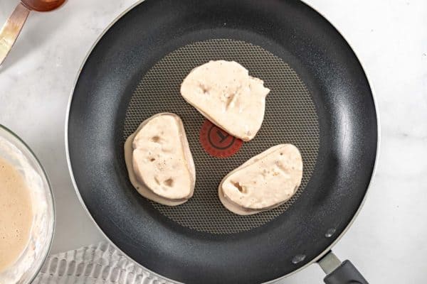 Tostadas francesas veganas crudas en una sartén negra.