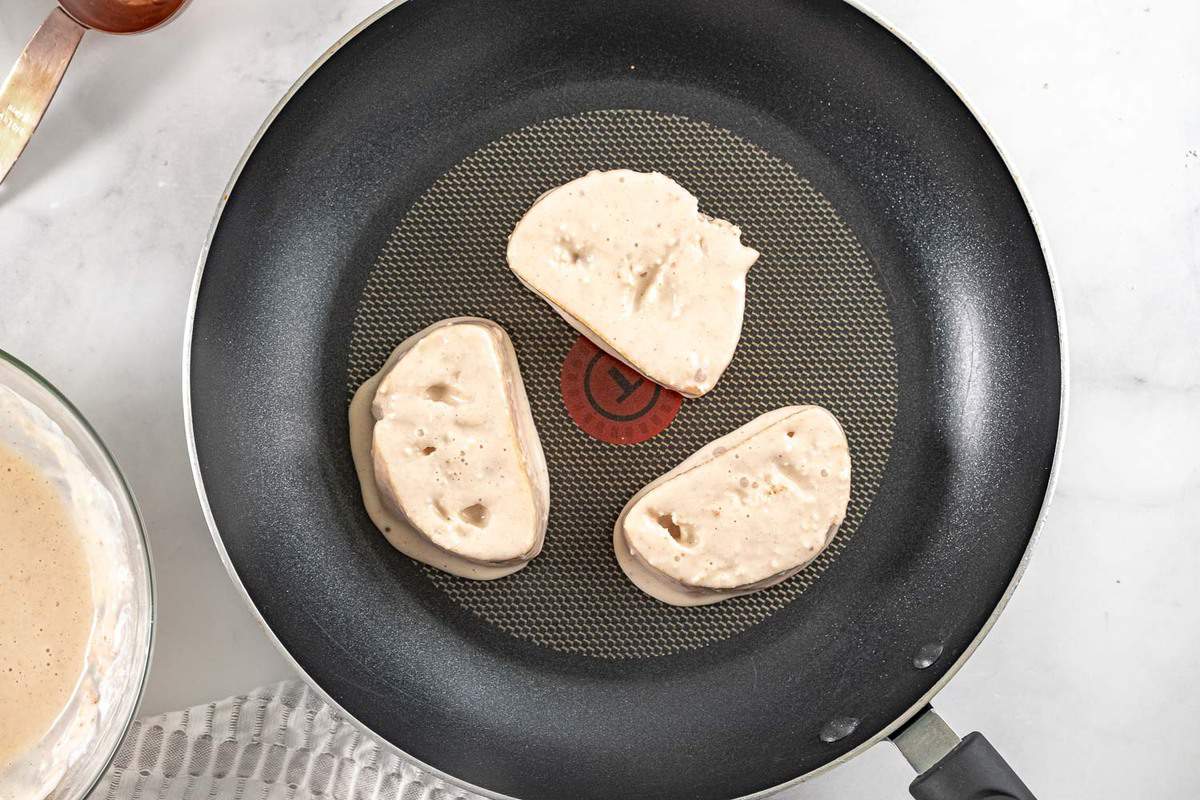 Tostadas francesas veganas crudas en una sartén negra.