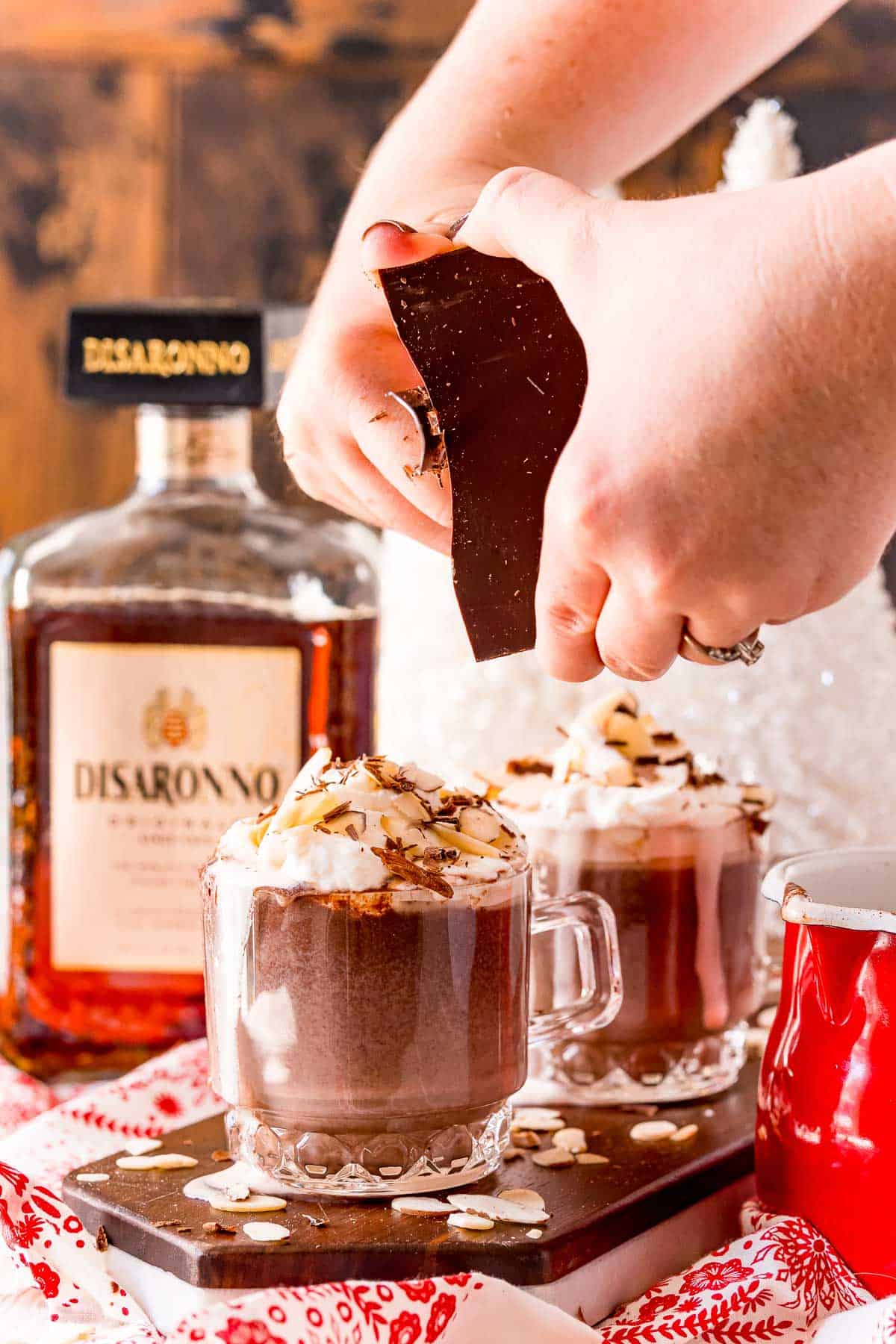 Virutas de chocolate siendo añadidas al cacao caliente.