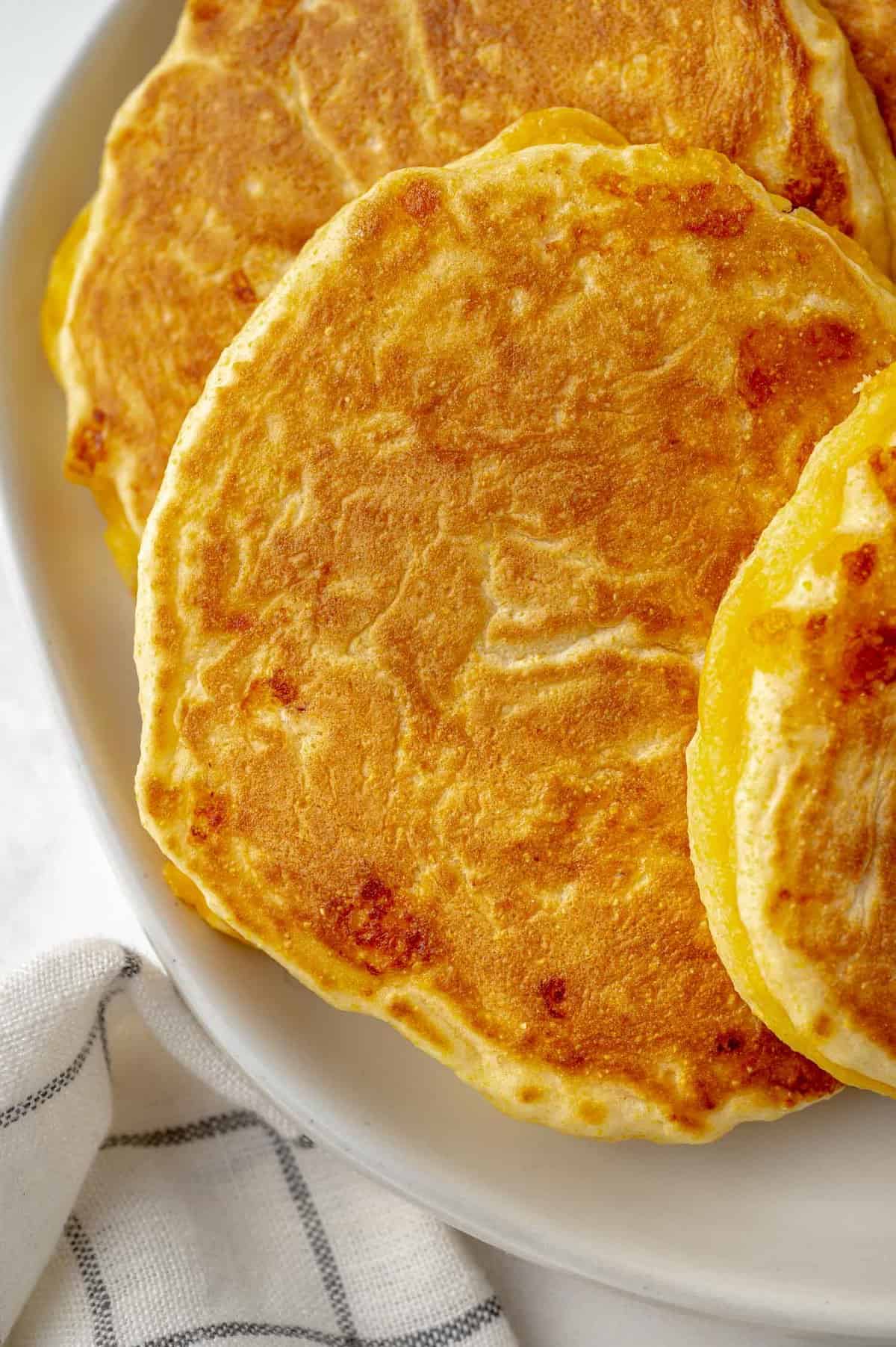 Vista cercana de un panqueque de harina de maíz con queso, mostrando el queso en el panqueque.