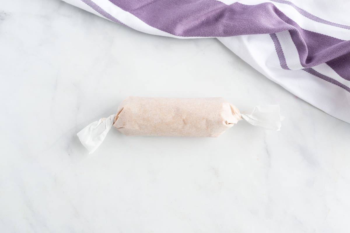 Mantequilla de canela y arce enrollada en papel encerado.