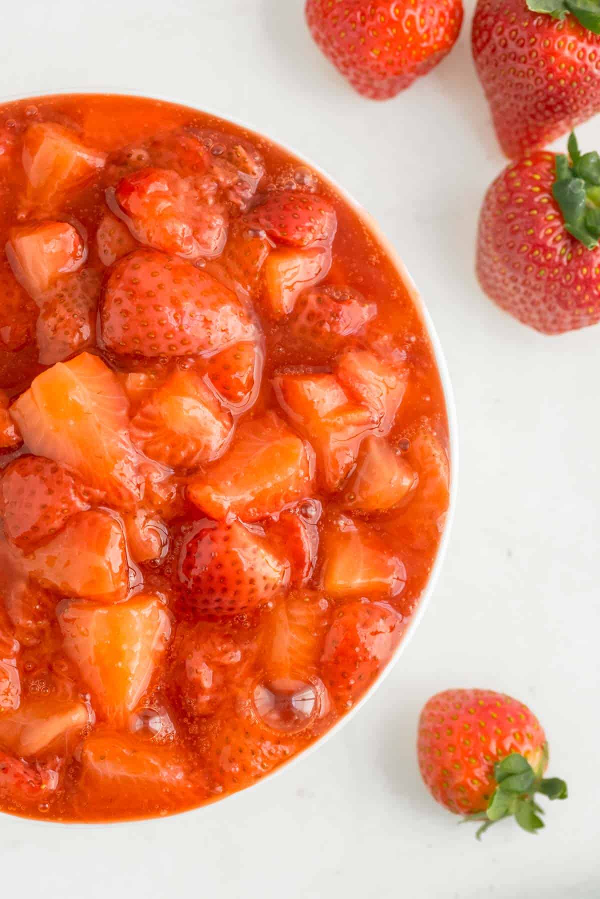 Primer plano de la salsa de fresas en un tazón blanco.