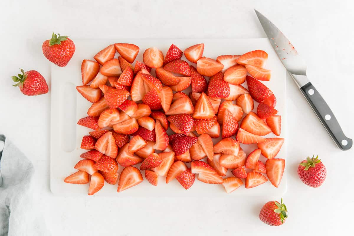 Fresas cortadas en una tabla de cortar.