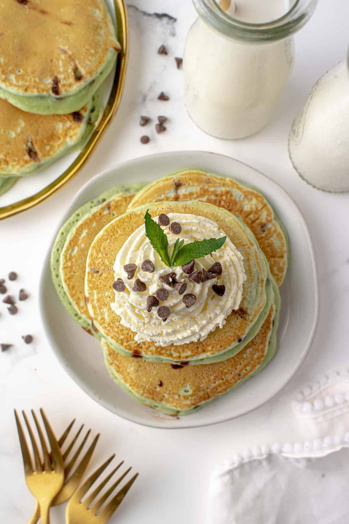 Plato de panqueques de chocolate con menta con crema batida y chispas de chocolate.