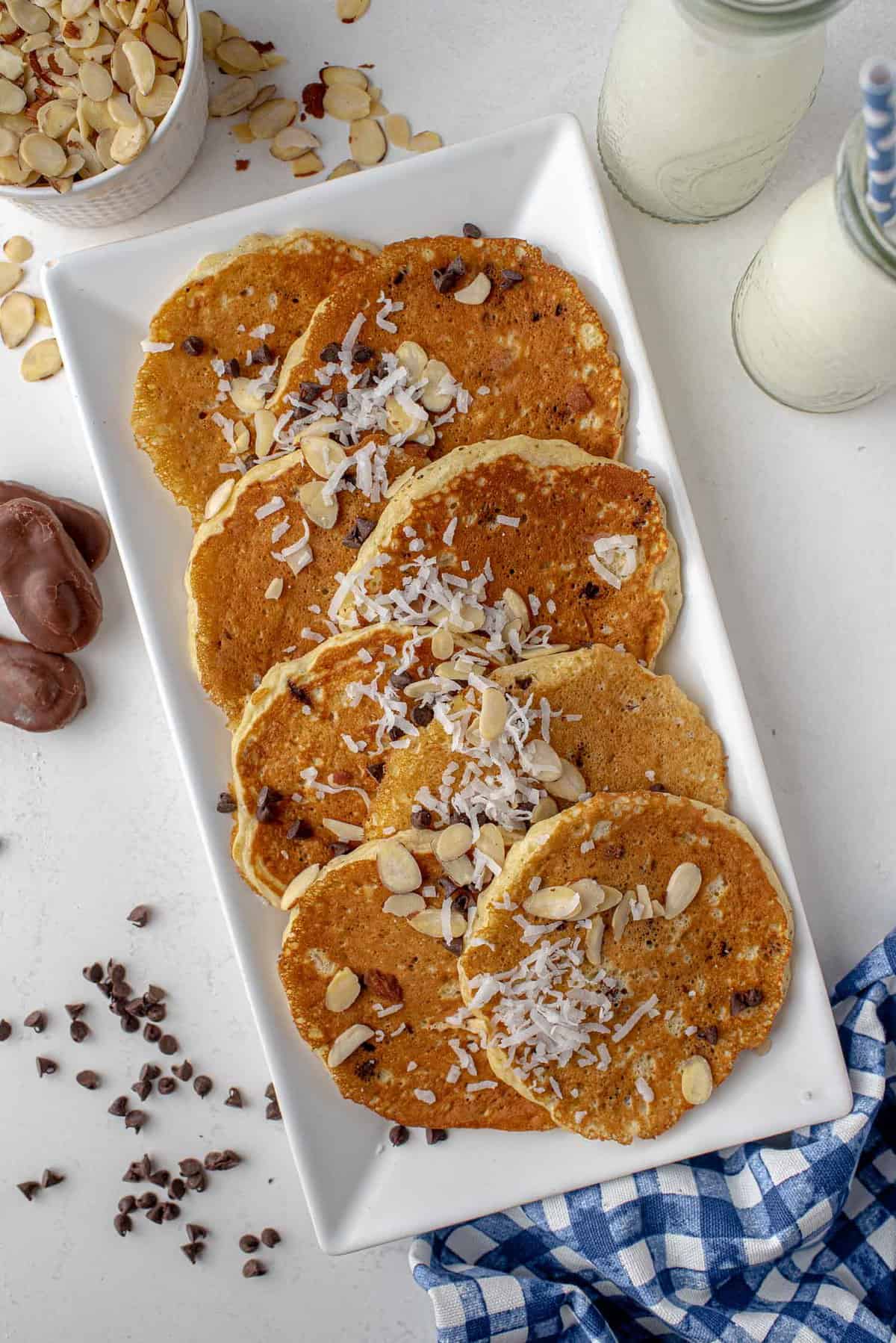 Panqueques Almond Joy en una bandeja espolvoreados con coco y mini chispas de chocolate.