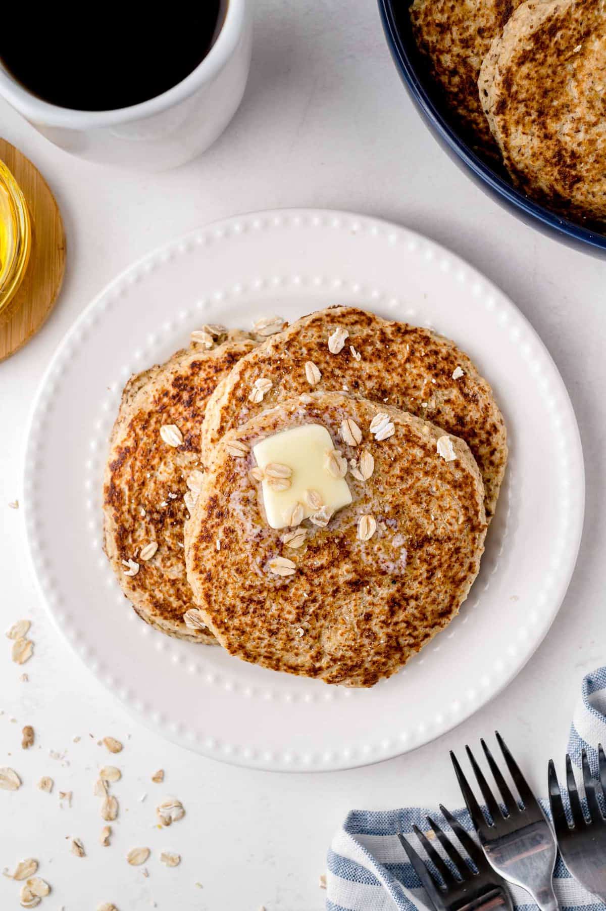 Tres panqueques cubiertos con mantequilla y avena.