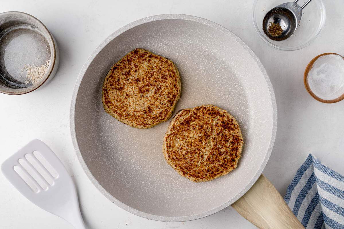 Panqueques de avena con miel en una sartén blanca.