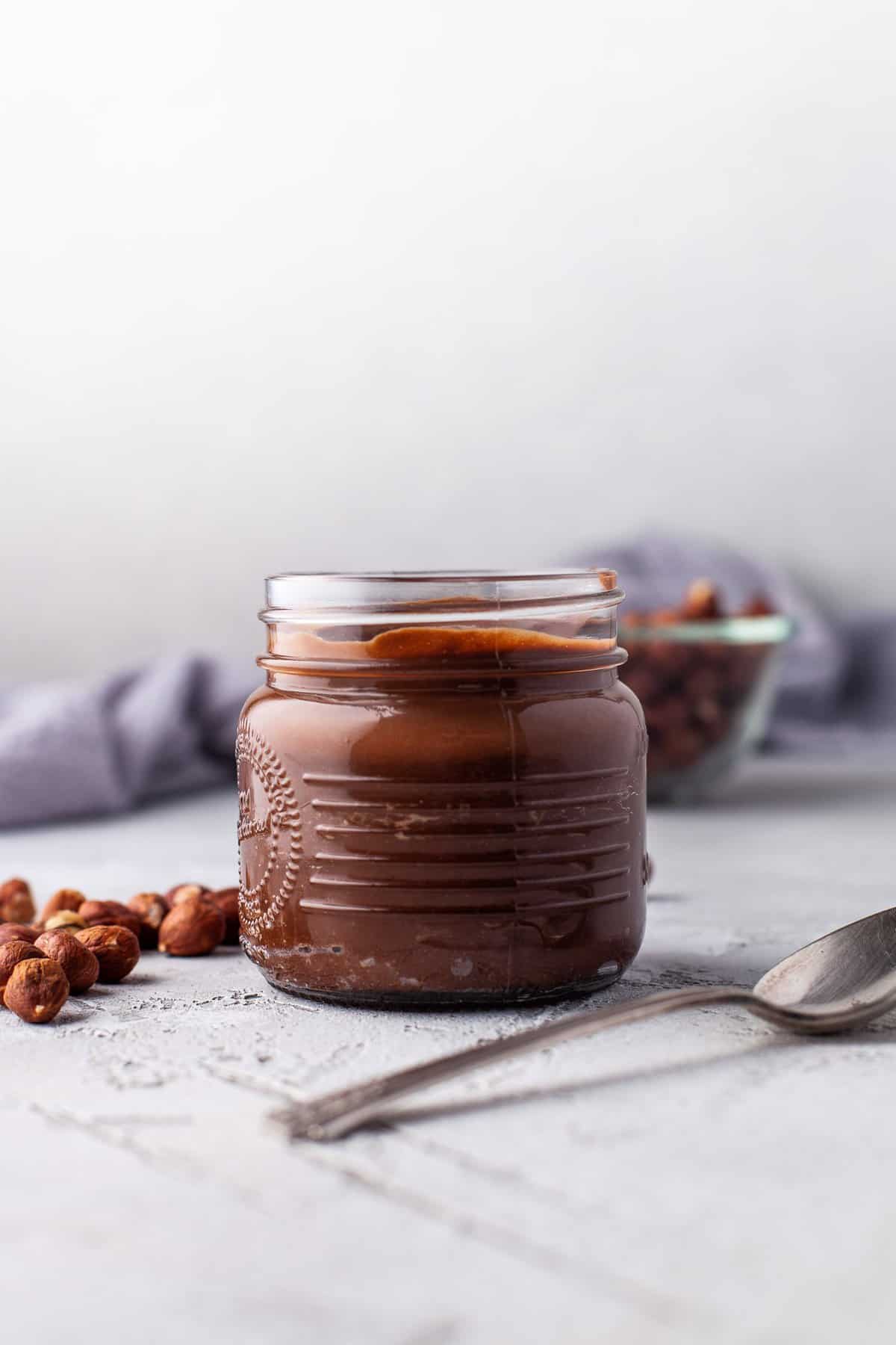 Nutella casera en un pequeño tarro de vidrio.