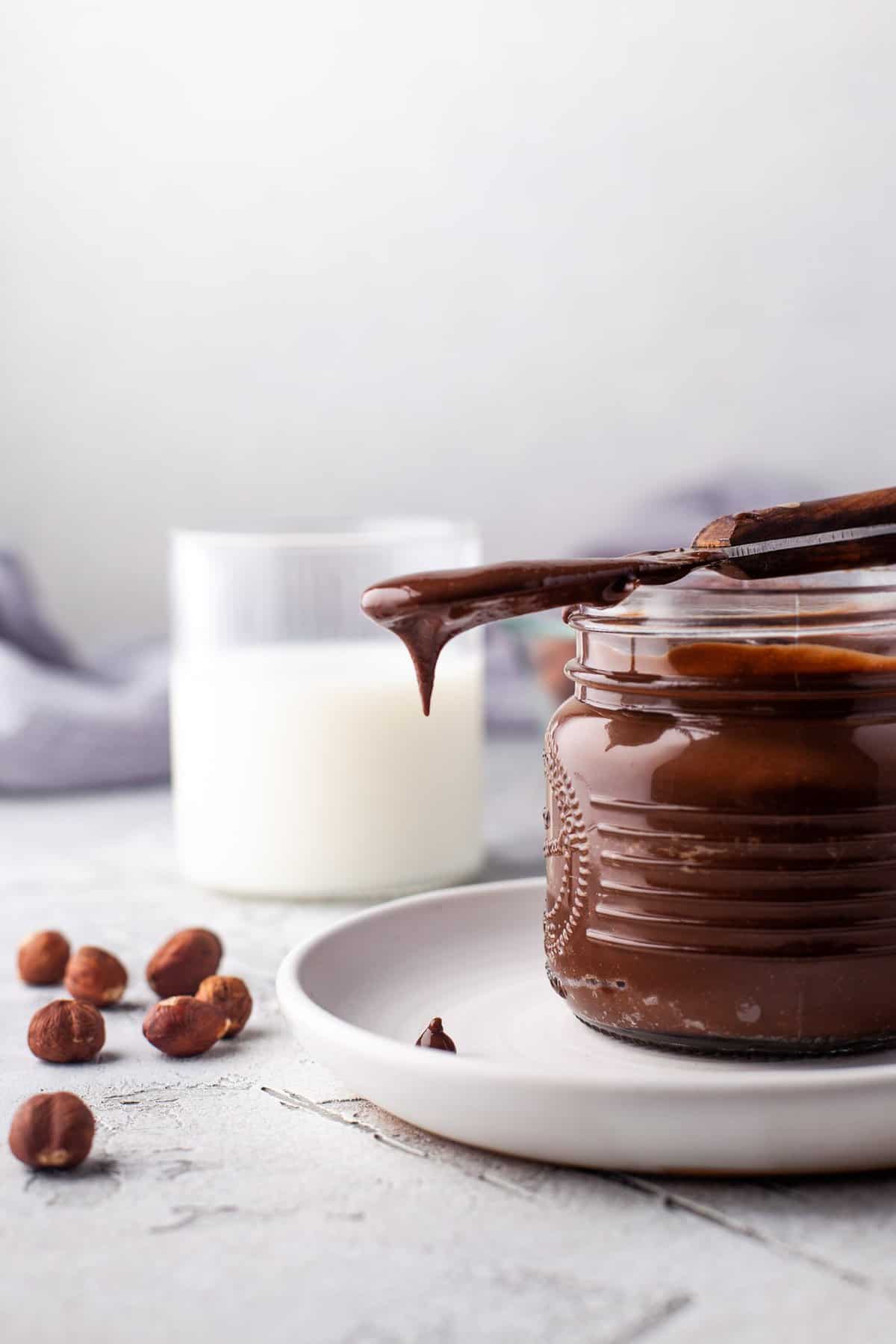 Nutella goteando de un cuchillo sobre un tarro.
