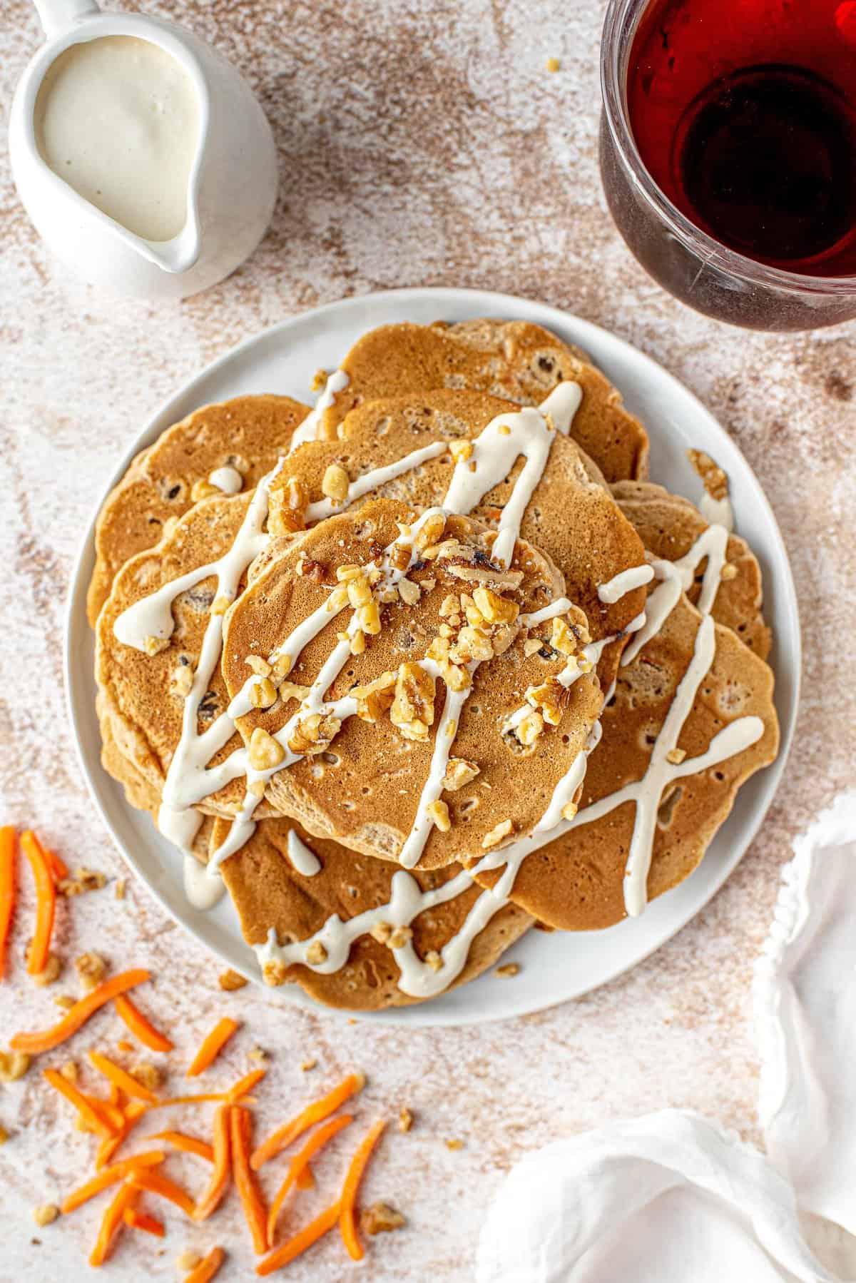 Plato de panqueques cubiertos con nueces y jarabe de queso crema.