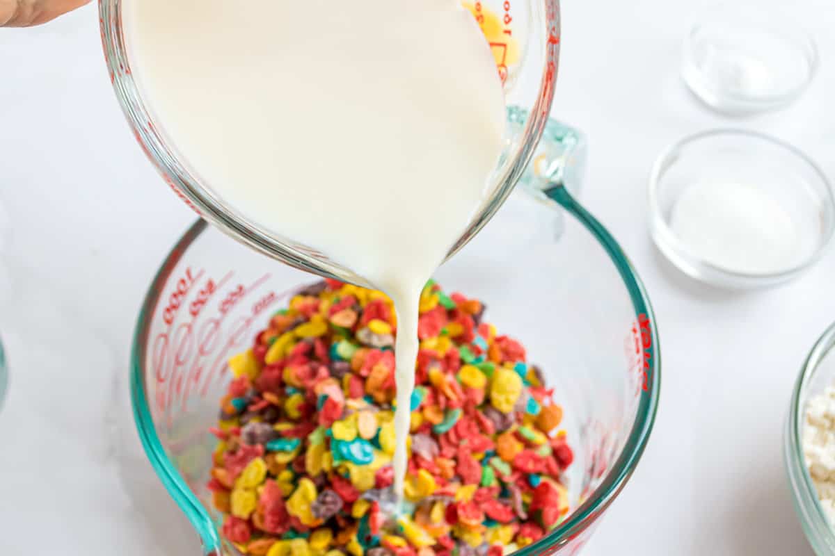 Leche siendo vertida sobre cereal.