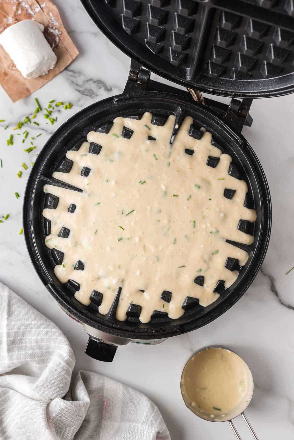 Masa de panqueque en una wafflera redonda.