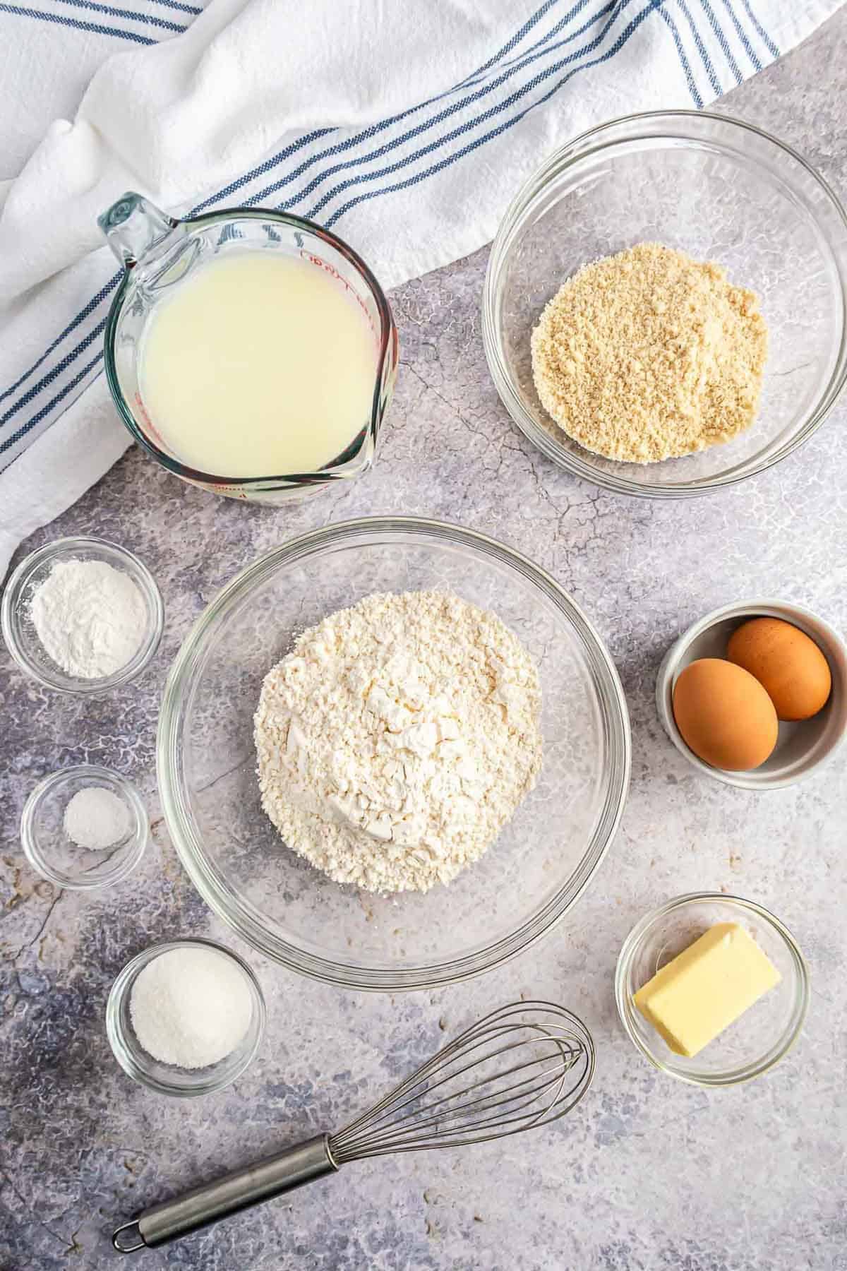 Vista aérea de los ingredientes en tazones sobre un fondo blanco y gris.