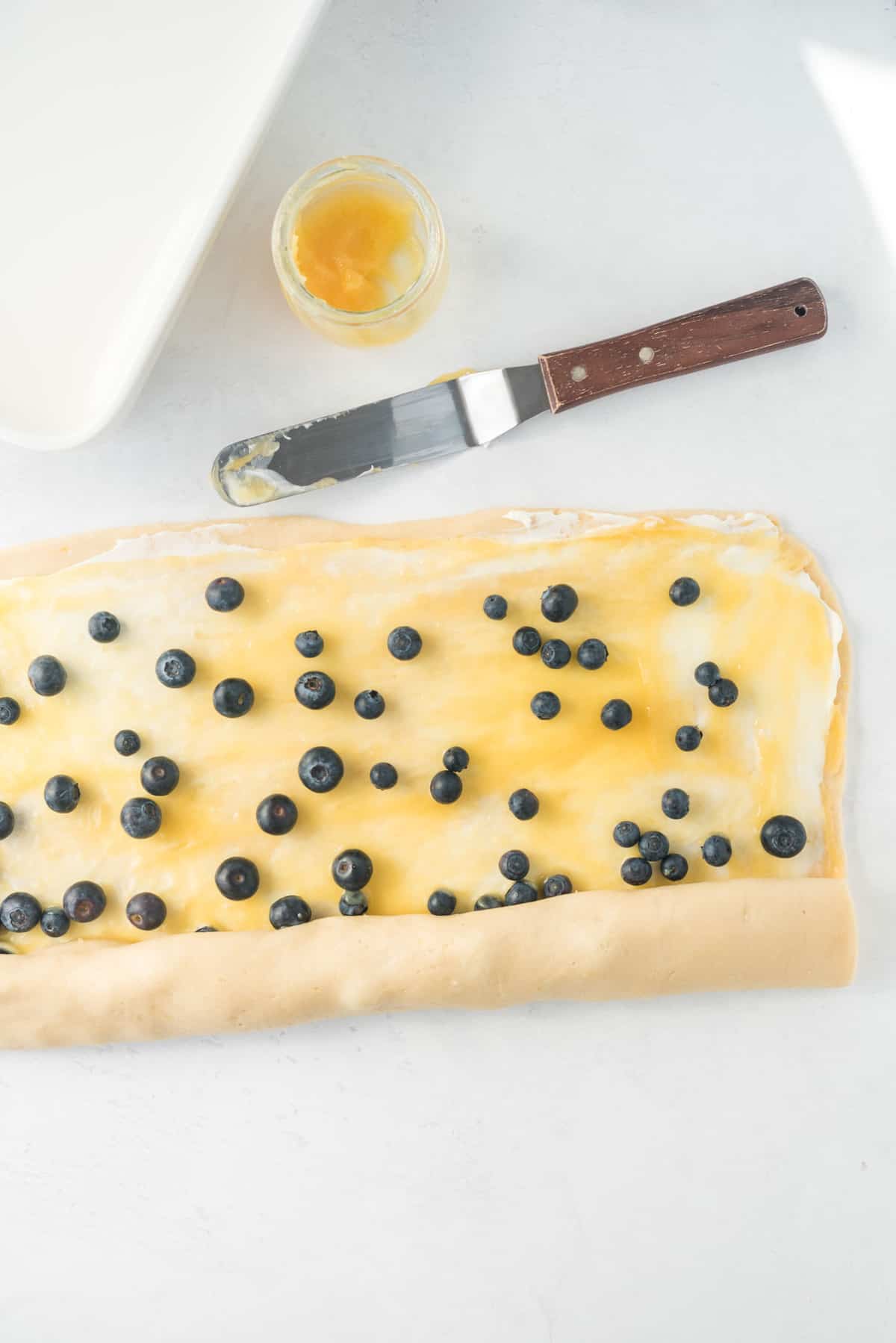 Masa rellena de arándanos siendo enrollada.