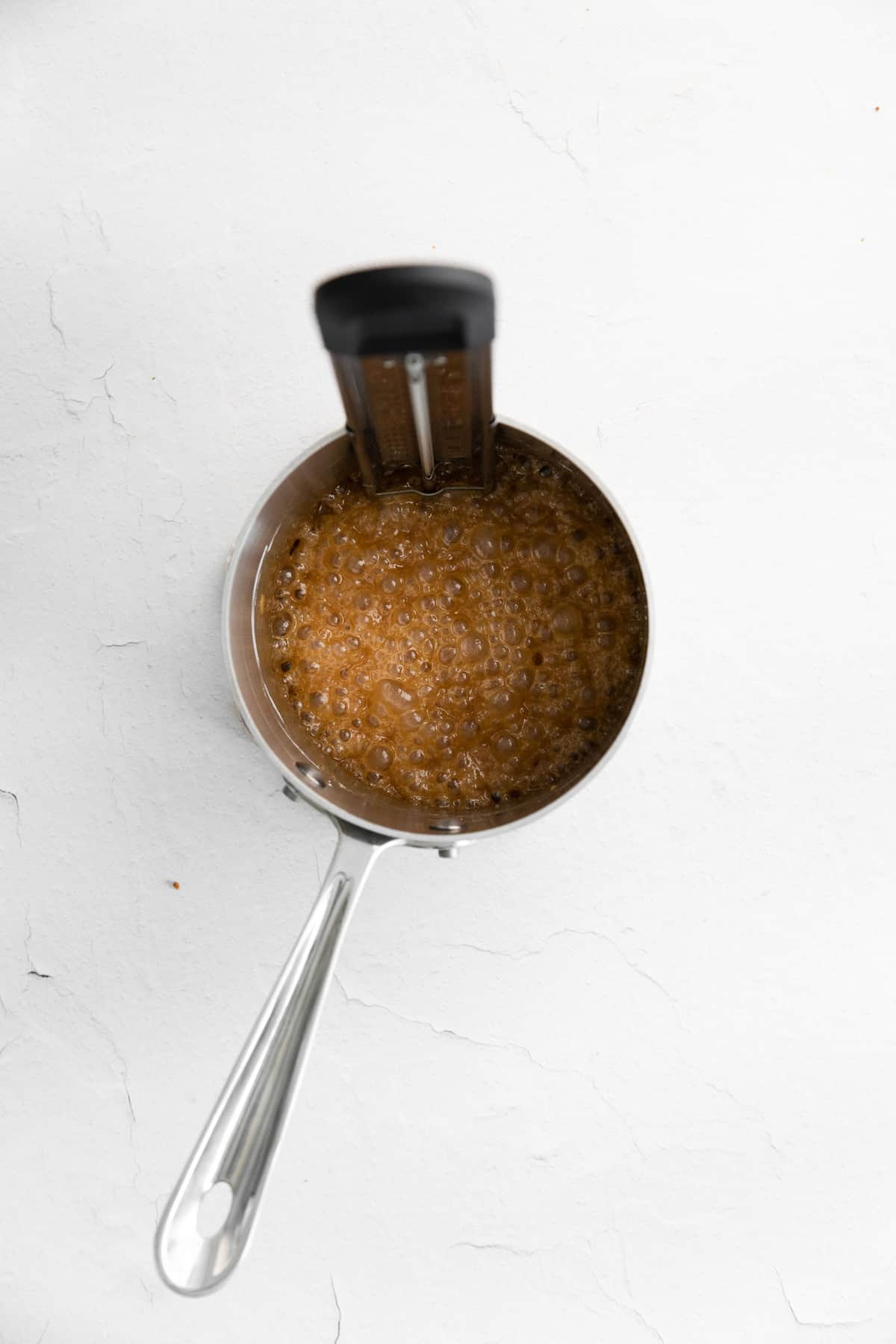 Caramelo cocinándose en una pequeña cacerola de metal.